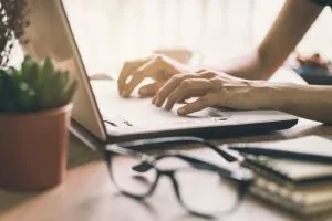 Businesswoman typing on laptop at workplace